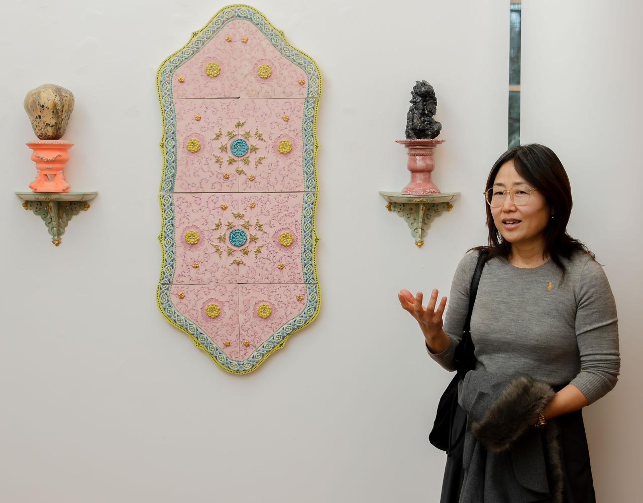 artist standing by one piece of her work