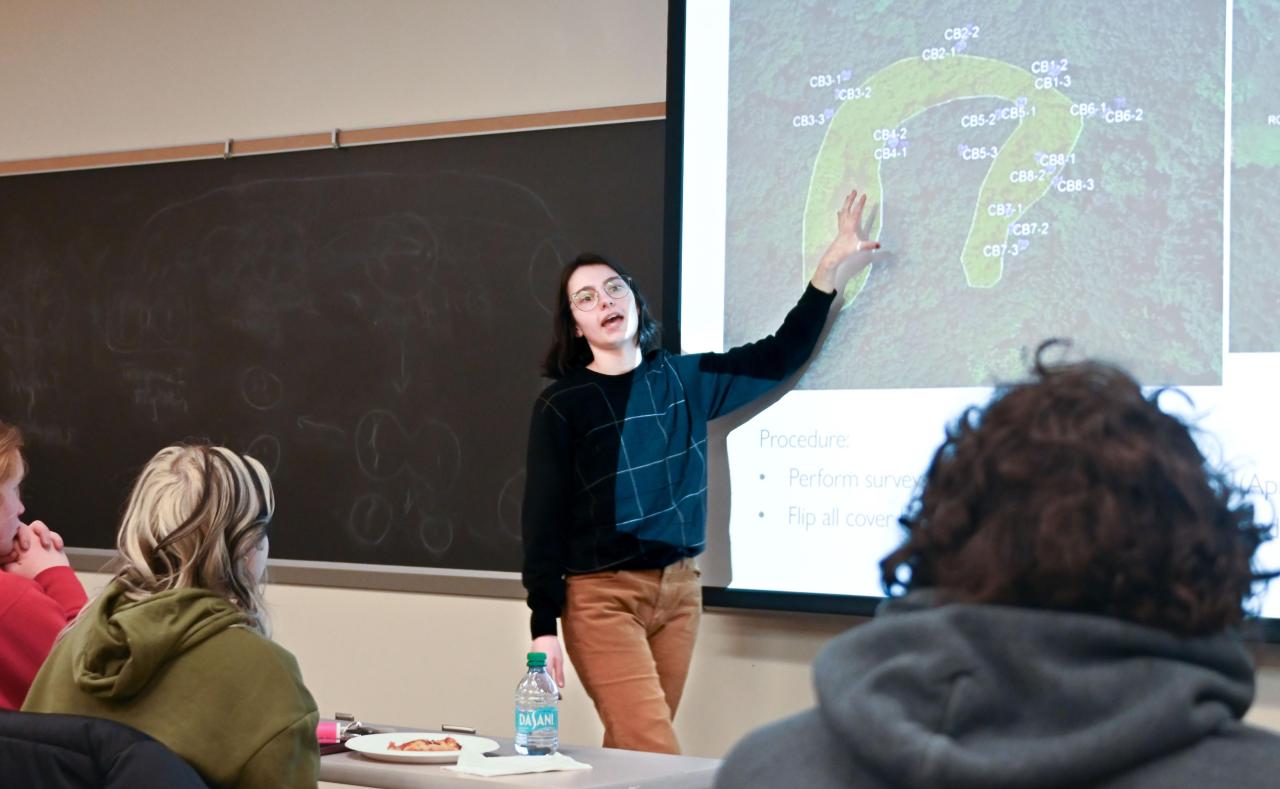 Kira Metzger in front of a classroom presenting her research