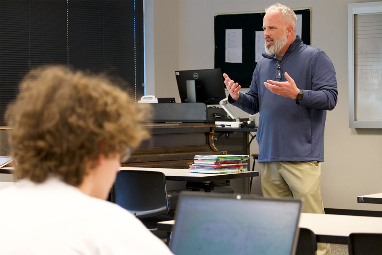 Bruce Dewey speaking in a classroom