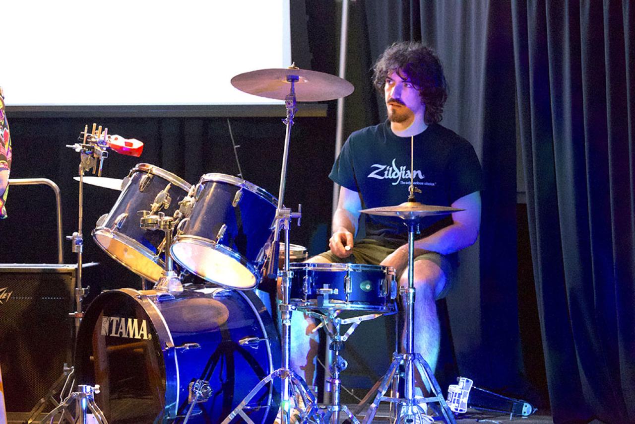 male drummer sitting at a drum kit in Club 419