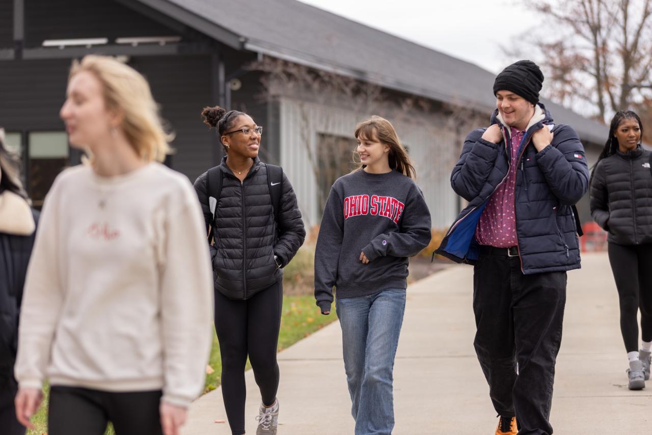 random group of students walking outdoors on campus