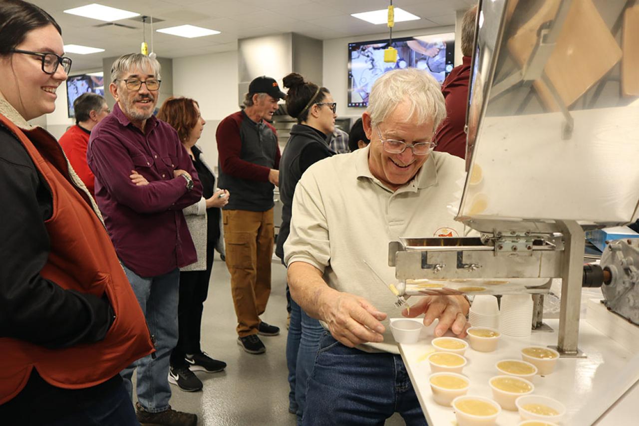 A maple producer teaches a class of workshop attendees how to make pure maple candy using silicon molds.