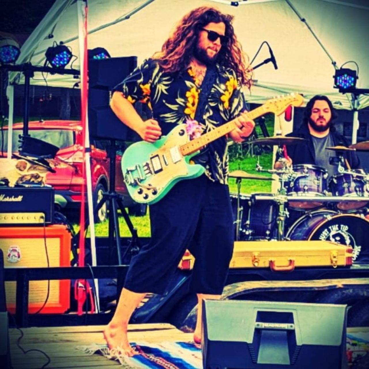 photo of musician Nate Wieland playing a guitar on stage