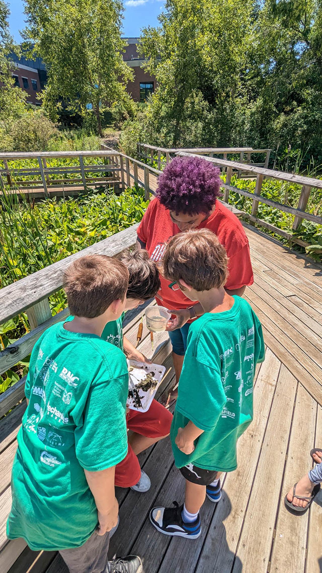 Dr. Adrienne Hopson helps a couple students from Springmill STEM Elementary identify aquatic macroinvertebrates collected from the Ohio State Mansfield Milliron wetland.