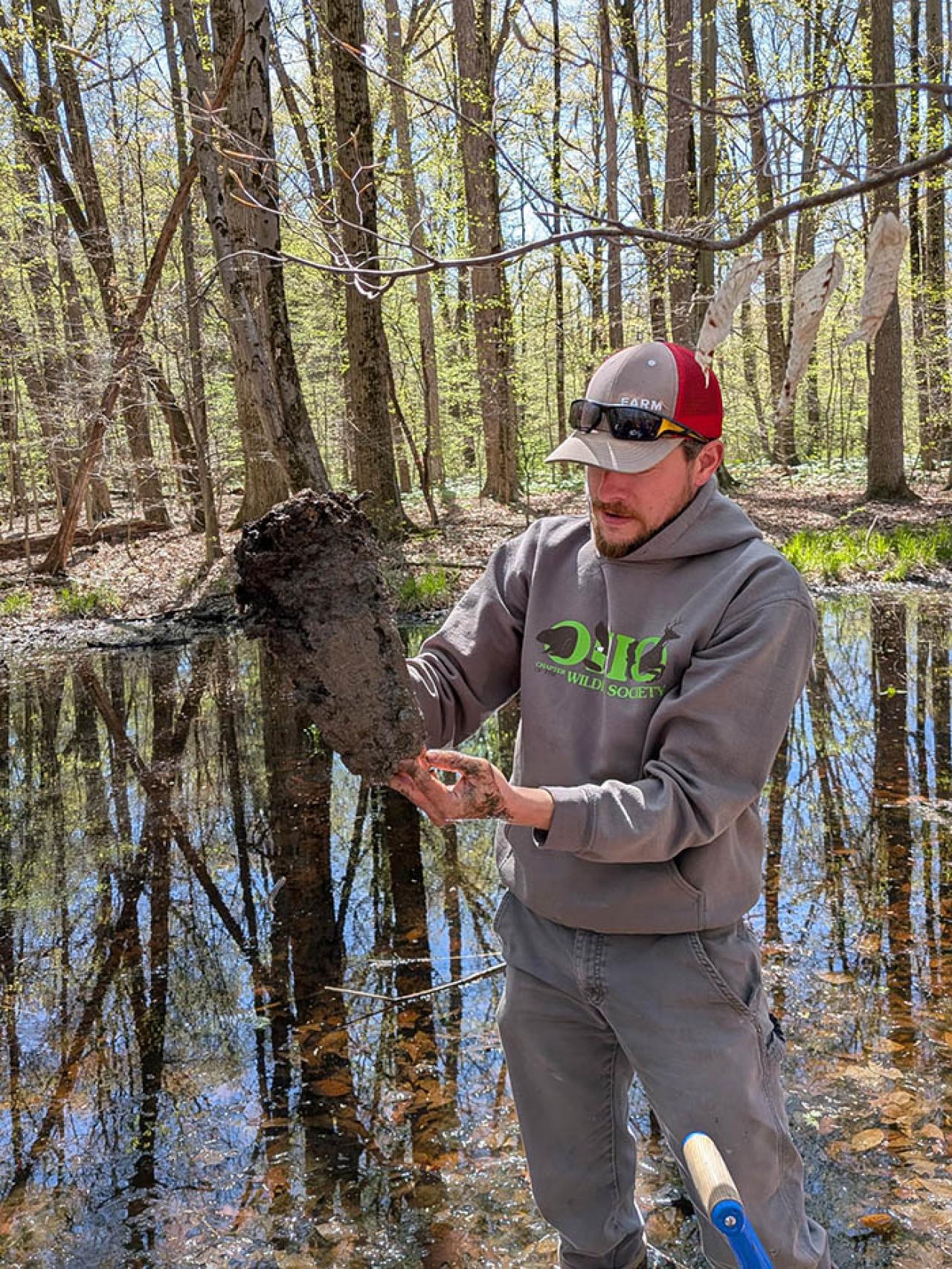 Dr. Gabriel Karns shows a hydric soil sample dug from the high water mark of the Horseshoe Wetland during an in-field lecture for ENR 2100 Intro to Environmental Sciences.