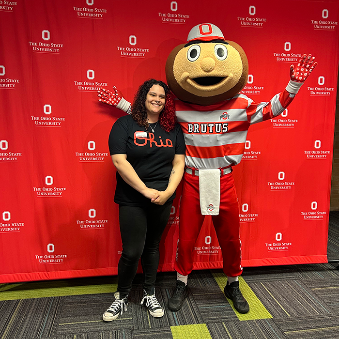 Student Rhea Oswalt posing with a brutus statue