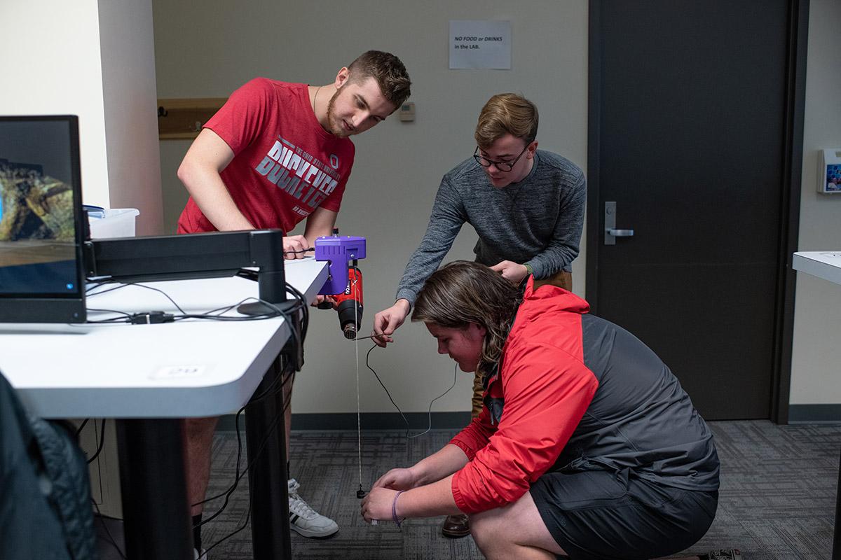 Three students collaborate on a project