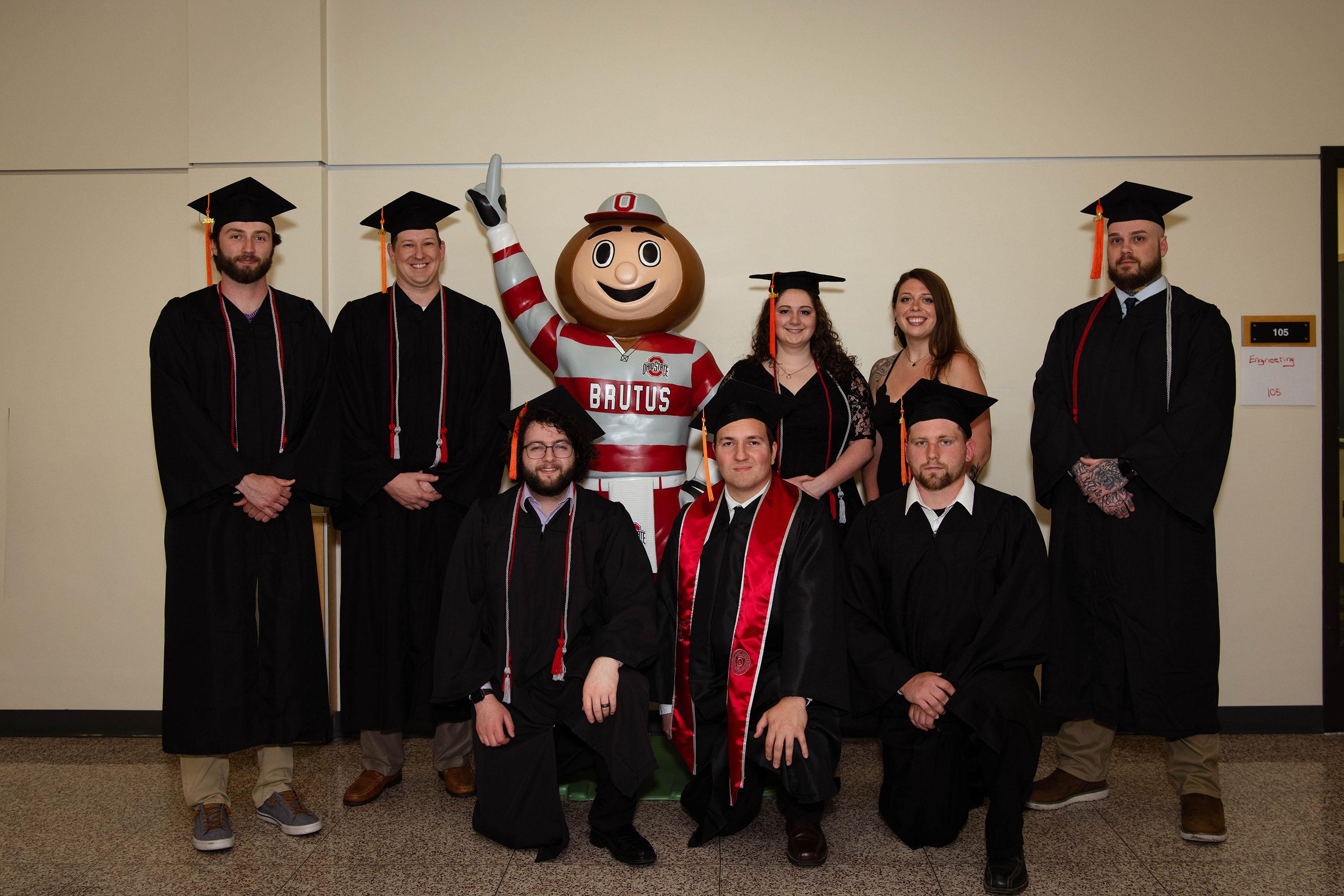 eight graduates of the engineering technology degree posing with Brutus Buckeye