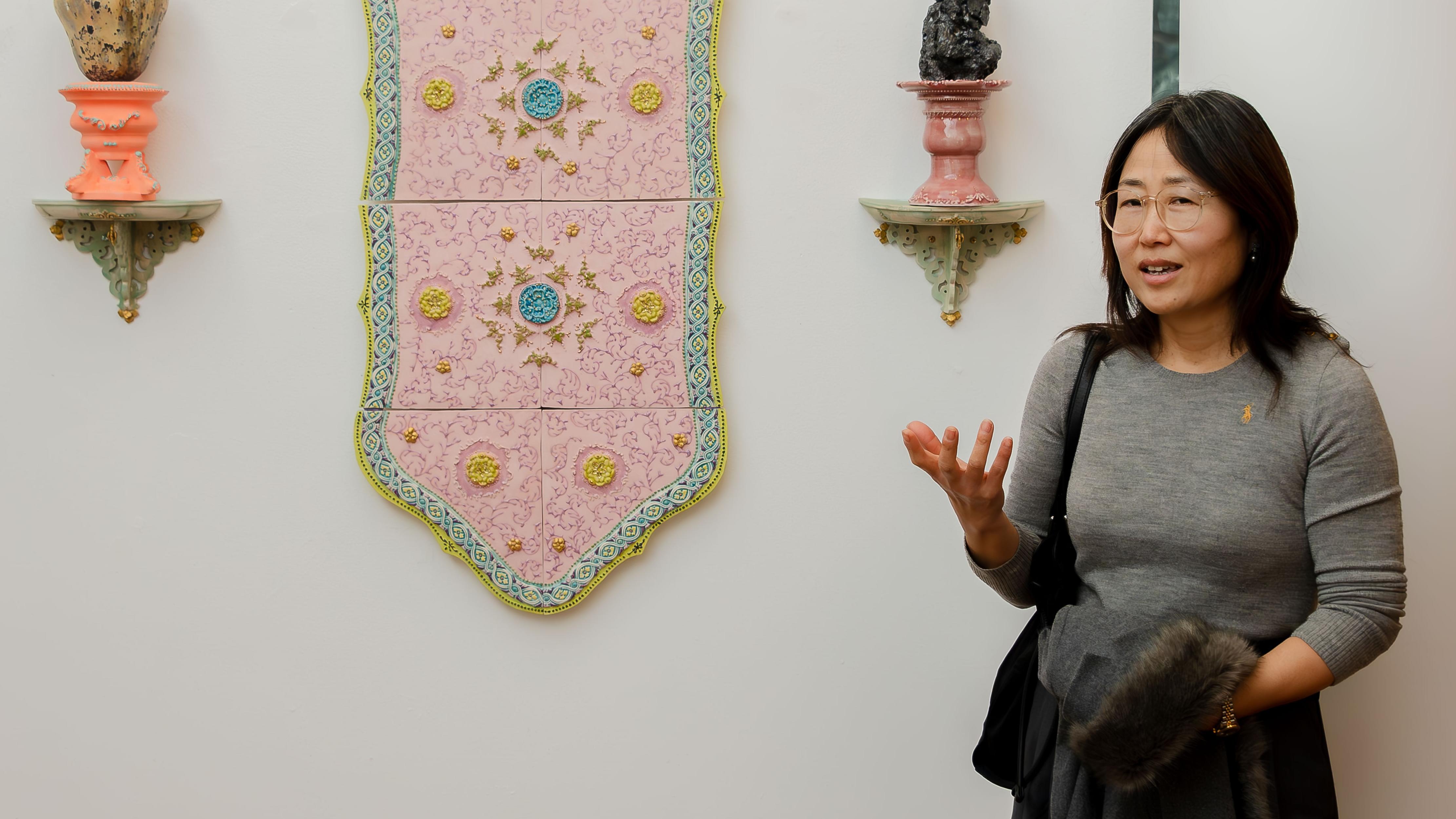 artist standing by one piece of her work