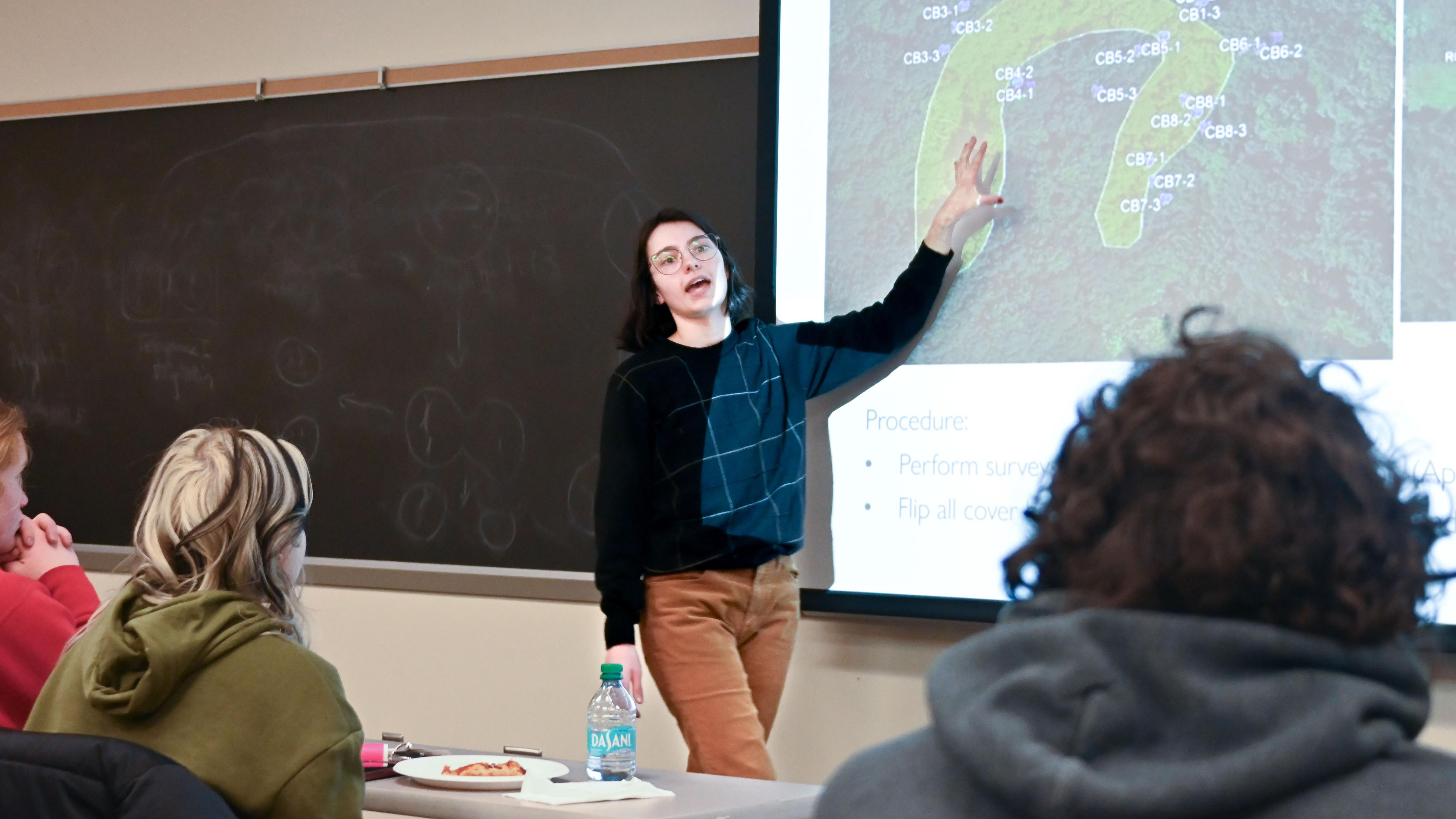 Kira Metzger in front of a classroom presenting her research