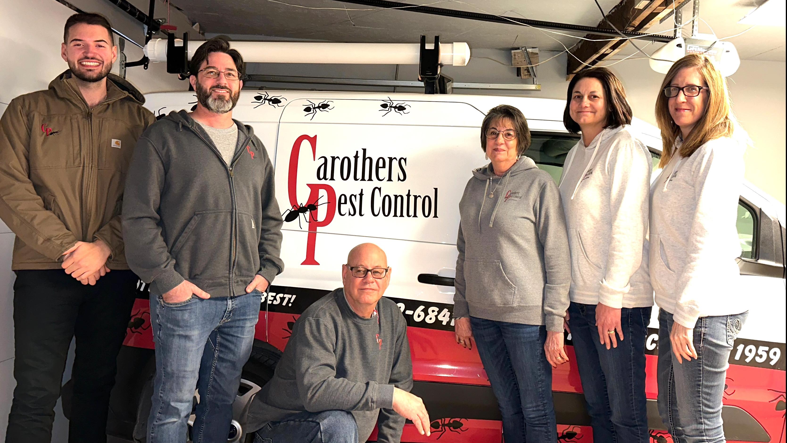 six carothers employees standing in front of their work truck