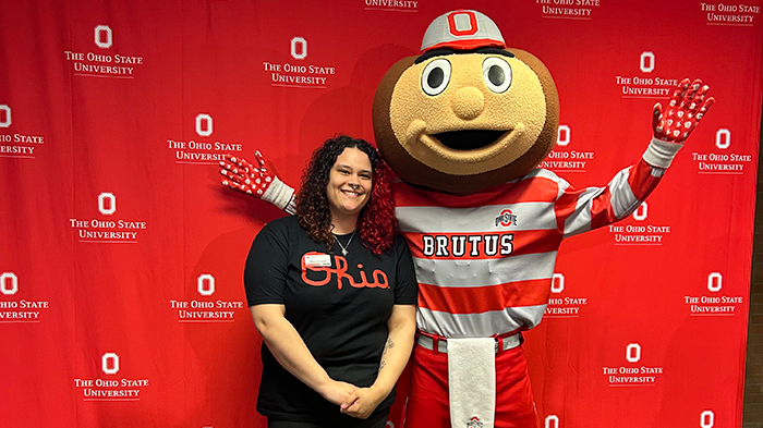 Student Rhea Oswalt posing with a brutus statue
