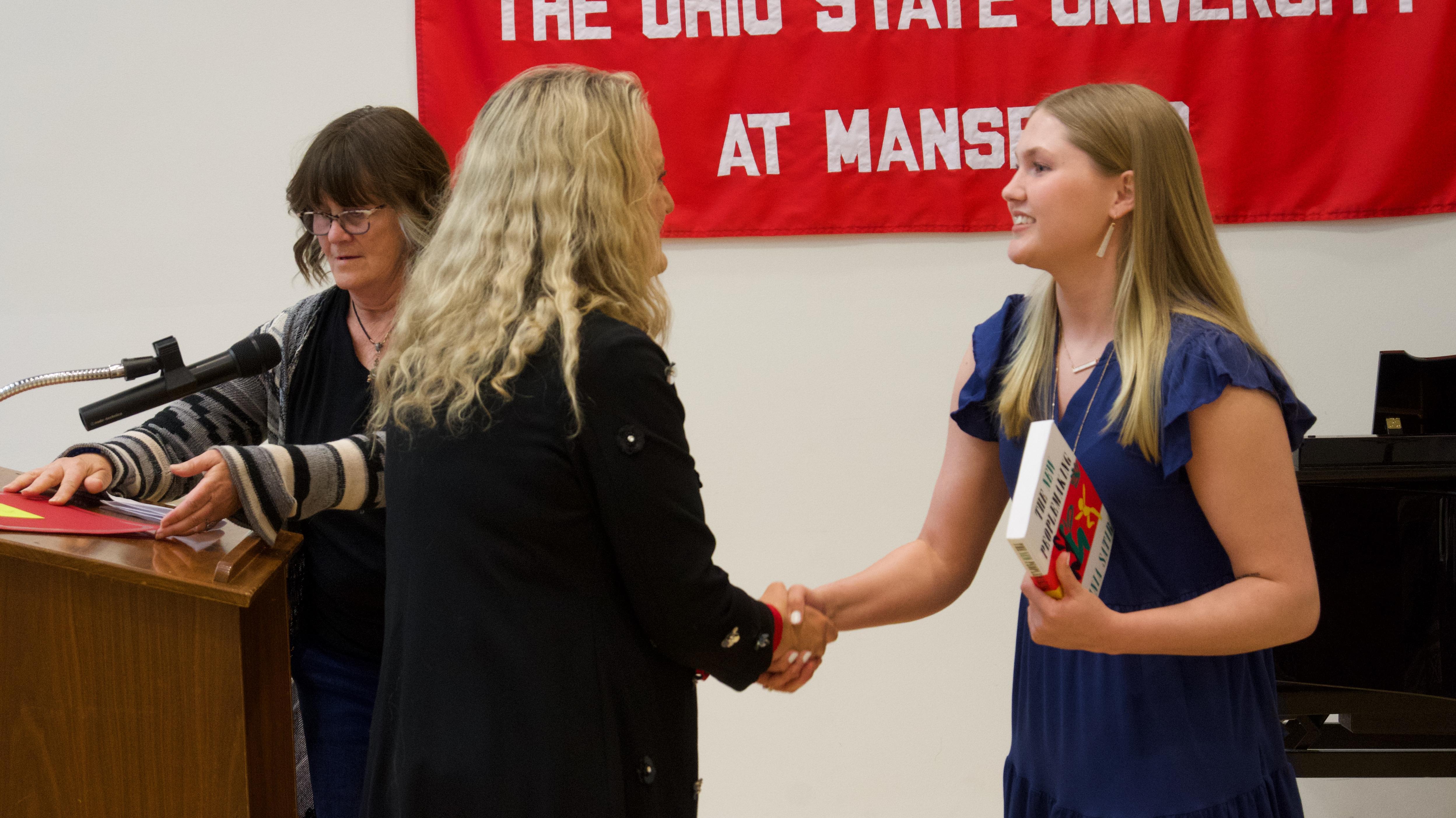 Taylor Kramer shaking hands at graduation