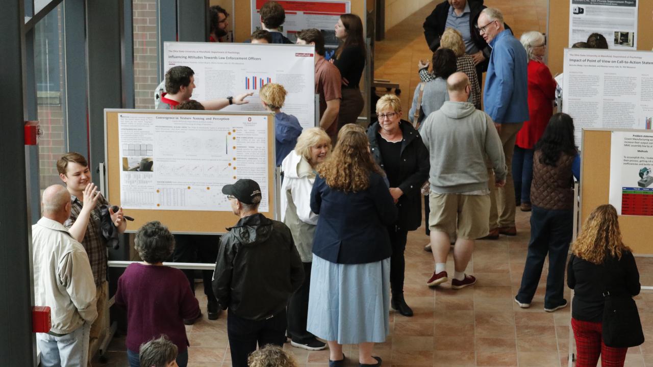 high angle photo of a group of people viewing student research posters