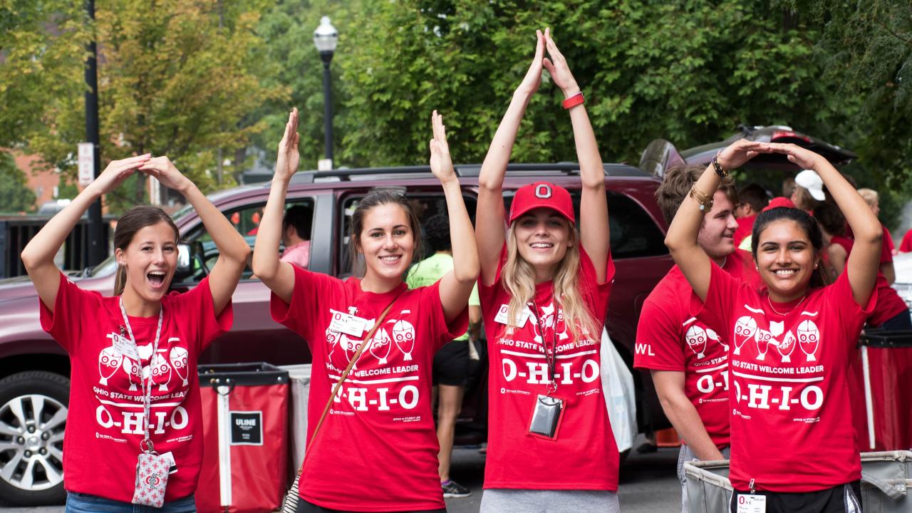 four students hold hand over their heads spelling Ohio