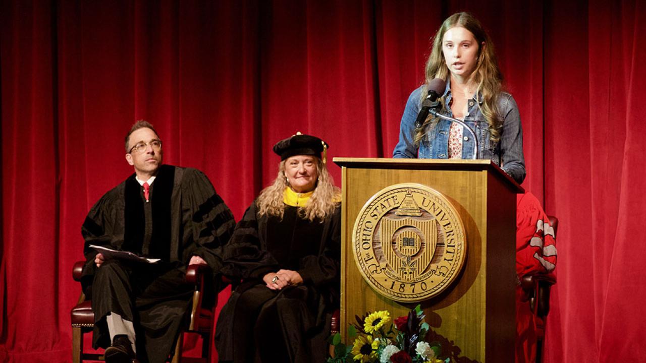 a female, makena, speaking on stage at convocation