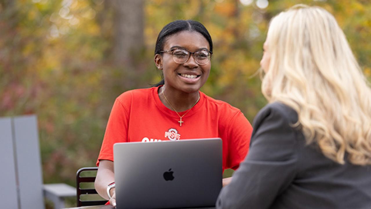 Students with a laptop talking outside at Ohio State Mansfield