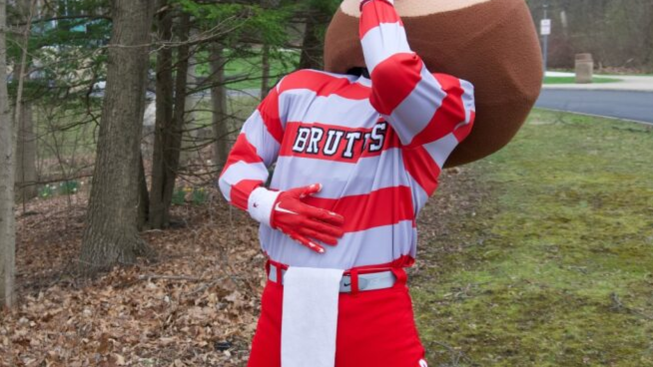 The Ohio State University mascot Brutus drinks from a half-gallon container of maple syrup.