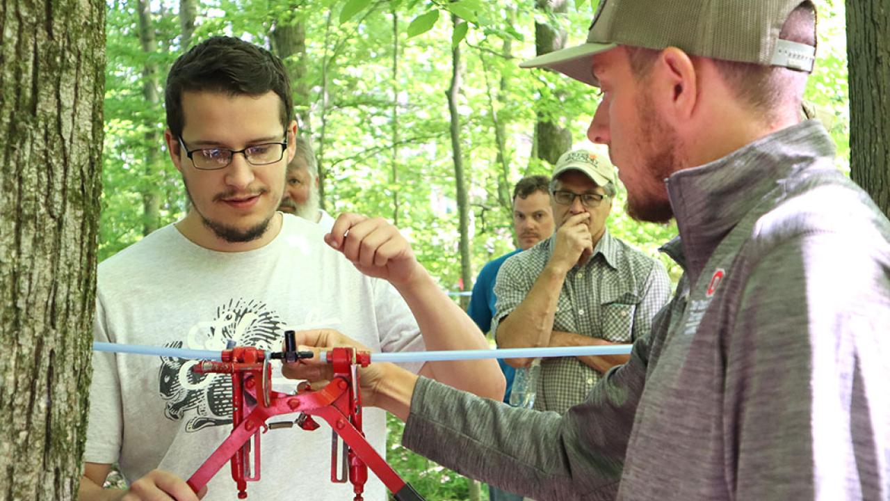A two-handed tool is used to connect tubing together in a maple vacuum system installation
